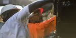 Two road construction workers work on a piece of heavy equipment on site of their construction careers in Georgia 