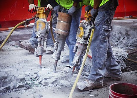 three Georgia highway construction laborers drilling up old pavement before they build a new road