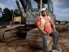 Gino Willis, a previous heavy equipment operator, smiles near a crane on a highway construction job site in Georgia.