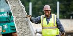 Luis Cervantes, a highway construction worker in Georgia, smiles while pouring concrete on site.