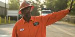Emmitt Hall, a worker who chose to have a highway construction career, smiles and waves to coworkers.