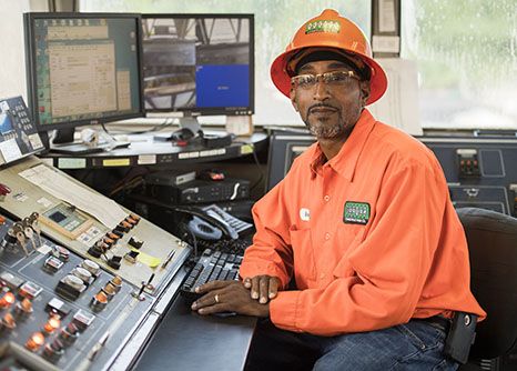 An asphalt plant operator sits at his desk. He enjoys his Georgia construction career