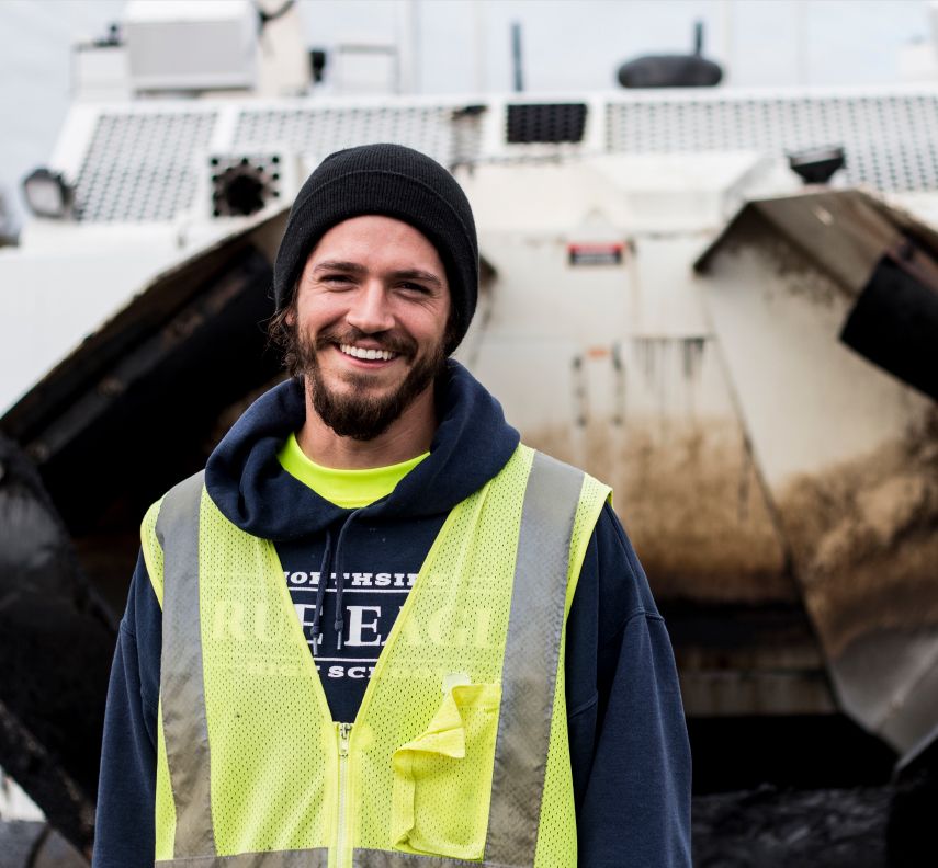 A young road construction worker smiles on site of his construction career in Georgia
