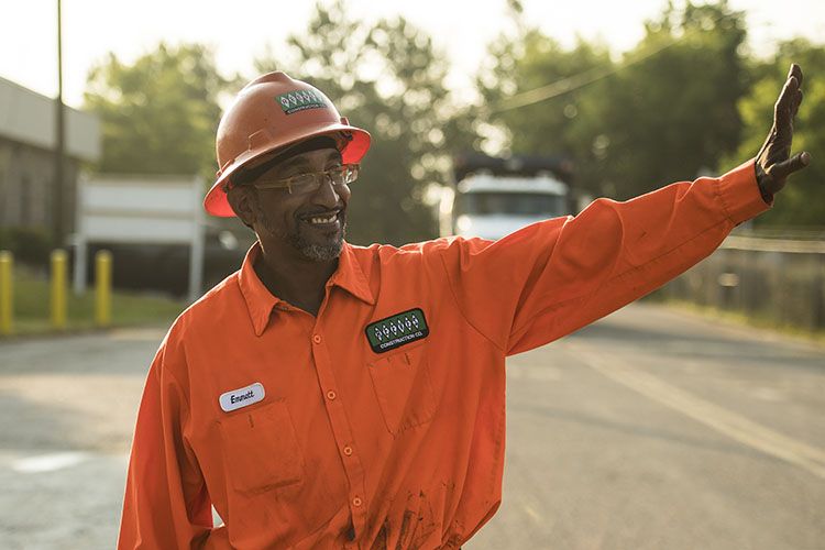 Emmitt Hall, a worker who chose to have a highway construction career, smiles and waves to coworkers.