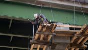 A bridge construction worker uses a hammer while on site of his highway construction career in Georgia