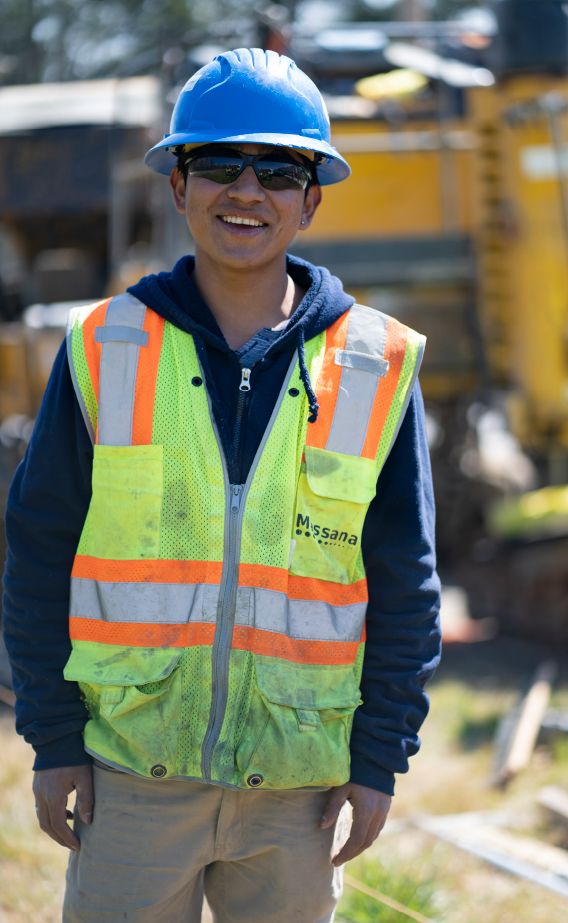 A young road construction worker smiles on site of his highway construction career in Georgia