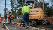 A asphalt paving worker uses a machine to help smooth out the ground on site of his road construction career in Georgia