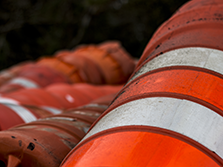 Bright orange construction cones are used on highway construction job sites to keep road construction workers safe