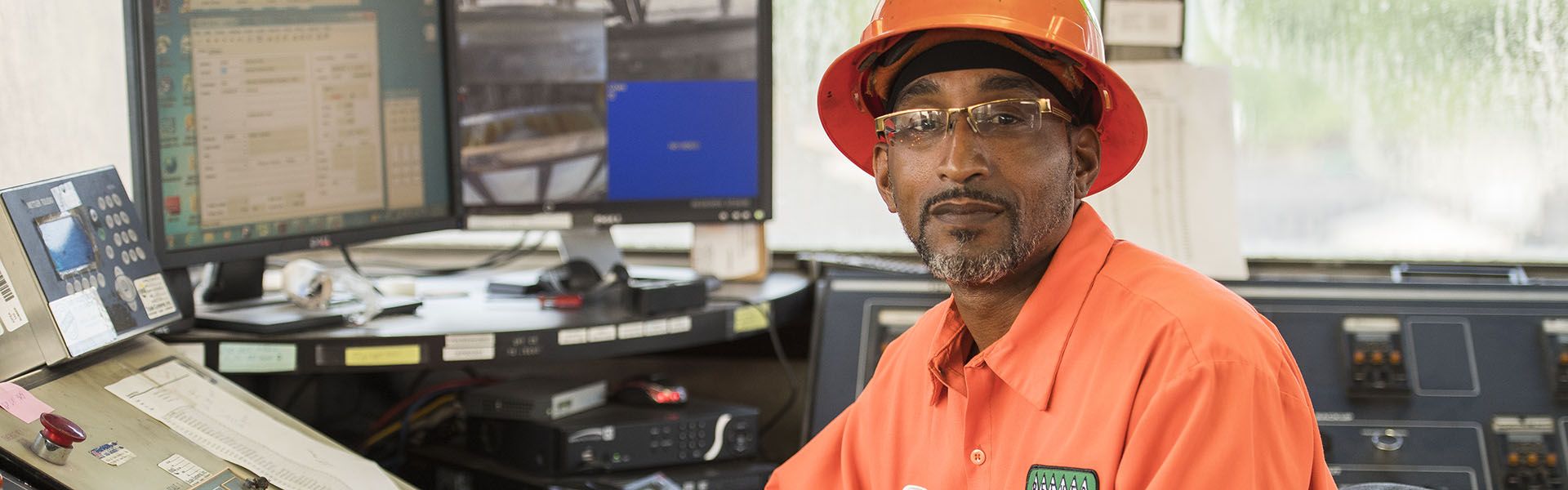 An asphalt plant operator in Georgia smiles at his desk on site of his highway construction career 