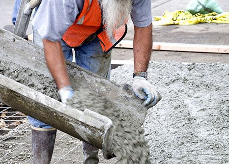 A concrete laborer pour concrete on site of his construction career in Georgia