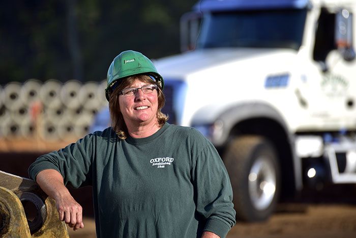 Melinda Vanhook is a CDL driver who works for a Georgia highway contractor. She smiles on her job site.