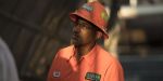 Road construction worker in Georgia wearing a hat listens to his heavy equipment operator about what needs to do be done.