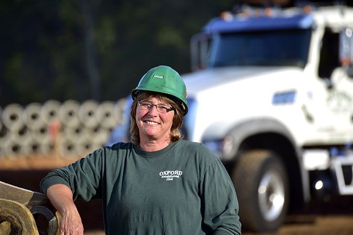 A woman CDL driver smiles on site of her Georgia road job