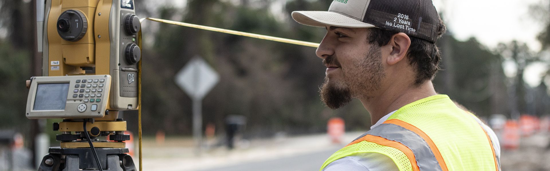 Young male road construction worker using state-of-the-art equipment on the site of his road construction job in Georgia