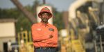 A road construction worker wearing an orange hard hat stands on site of his road job in Georgia