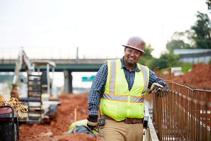 Luis Cervantes smiles on a construction site because he loves his Georgia construction career.