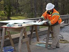 A highway bridge carpenter reviews the blueprint of a bridge he is building during his road construction career in Georgia