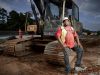 Gino Willis, a foreman for a Georgia highway construction company, smiles near a crane on a job site.