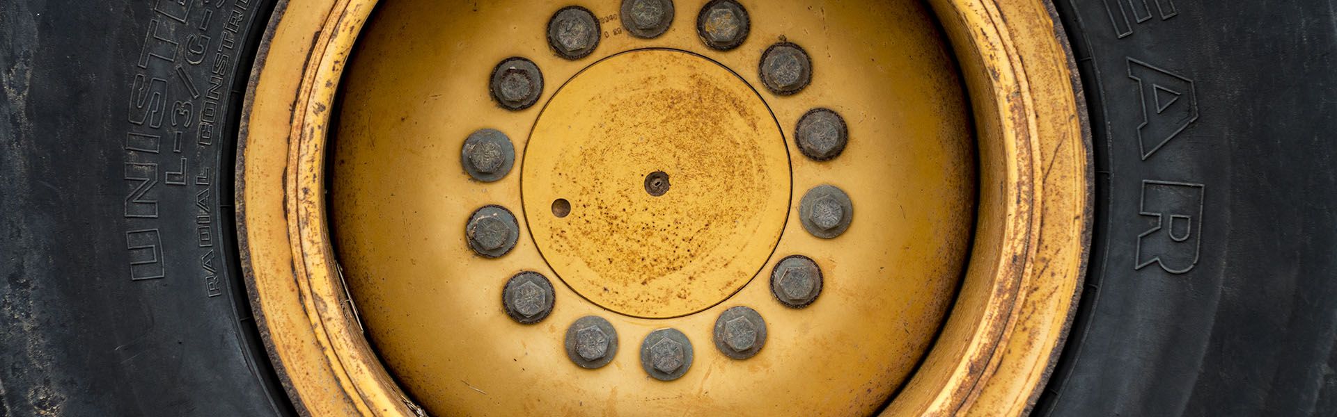 A yellow hubcap connected to a tire of a piece of heavy equipment use on Georgia road job sites