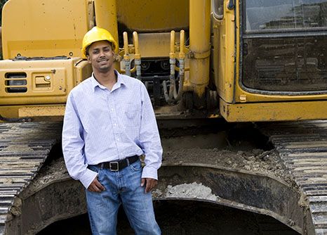 Young male heavy equipment operator smiles on site of his road construction job in Georgia